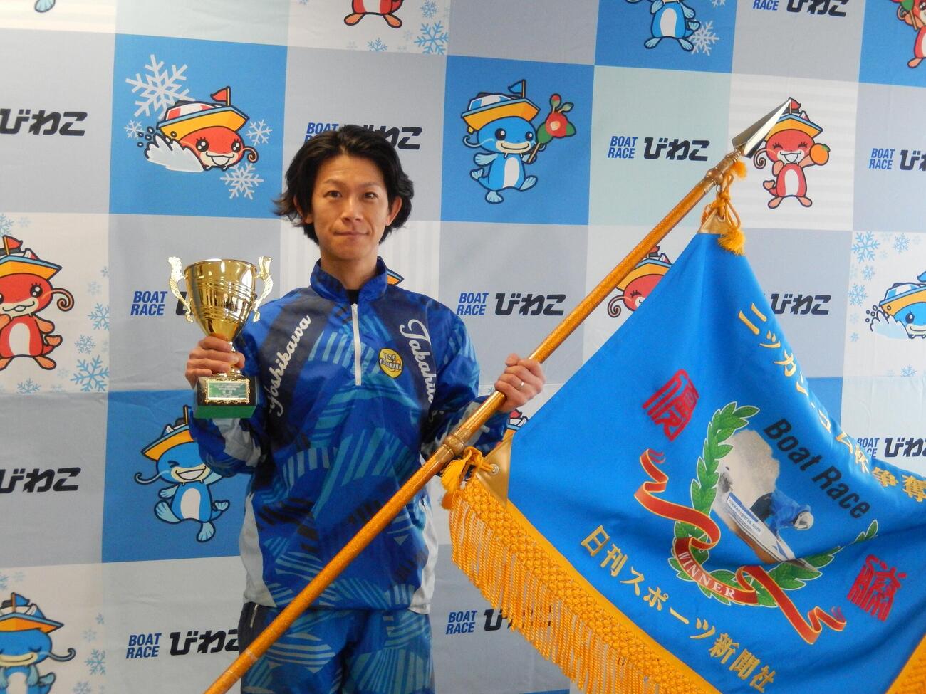 優勝の吉川貴仁が優勝カップと優勝旗を手に笑顔