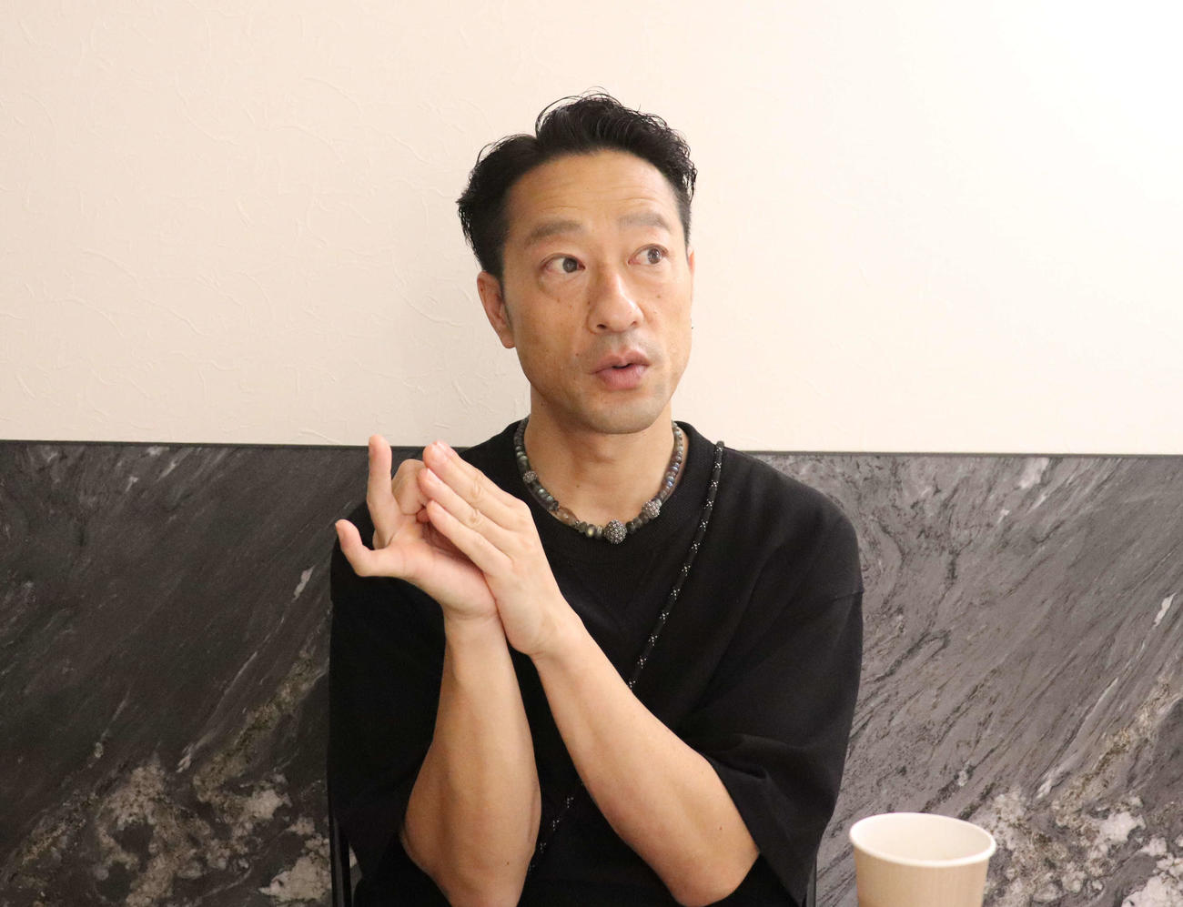 記者の取材に応じる新藤哲三さん