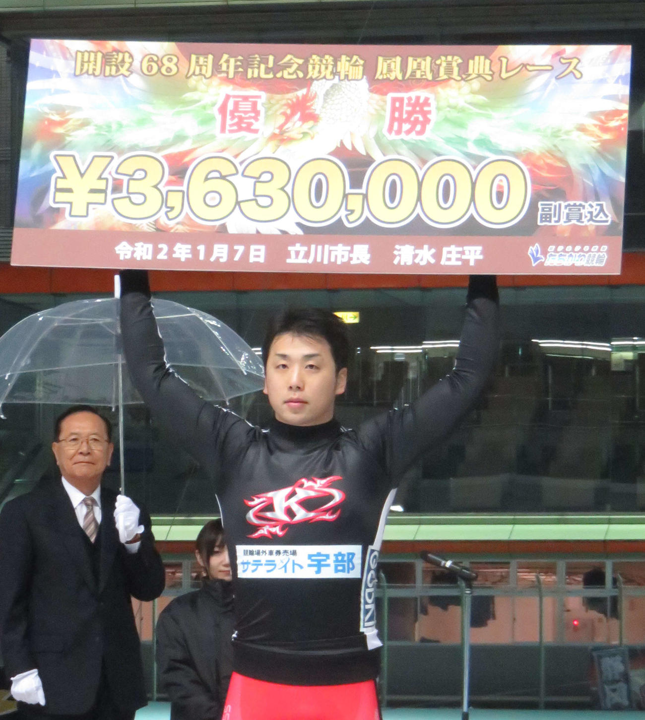 連覇を達成して賞金ボードを掲げる清水裕友