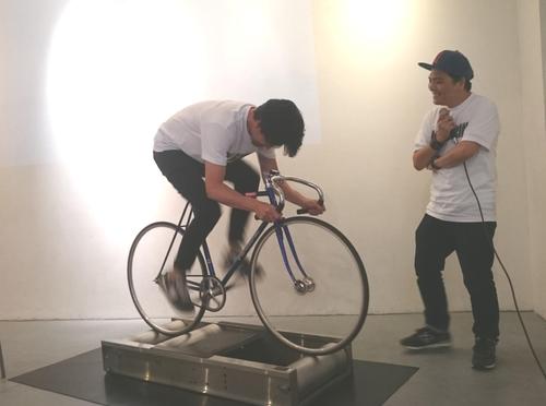 安部賢一（左）はローラーで自転車をこぎ、時速６４キロを記録。主人公を演じた脚力を披露し会場はどよめく。若いころは競輪選手を目指した（１８年５月１８日撮影）