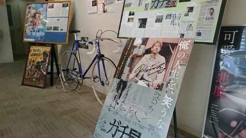 劇場ロビーに飾られている実際に使用された自転車やサイン入りパネル。
