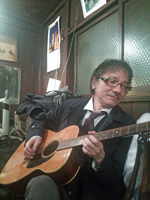 ４年前の暮れ、居酒屋にあったギターを手にする棚町さん。即興で「まる儲け♪まる儲け」歌っていました