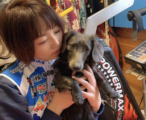 室内トレーニングの様子をのぞく、愛犬の雄ダックスフント「ロン」を抱きしめる