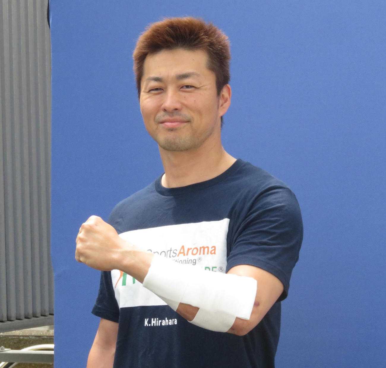 負傷した左腕を見せながら「大丈夫」とアピールする平原康多