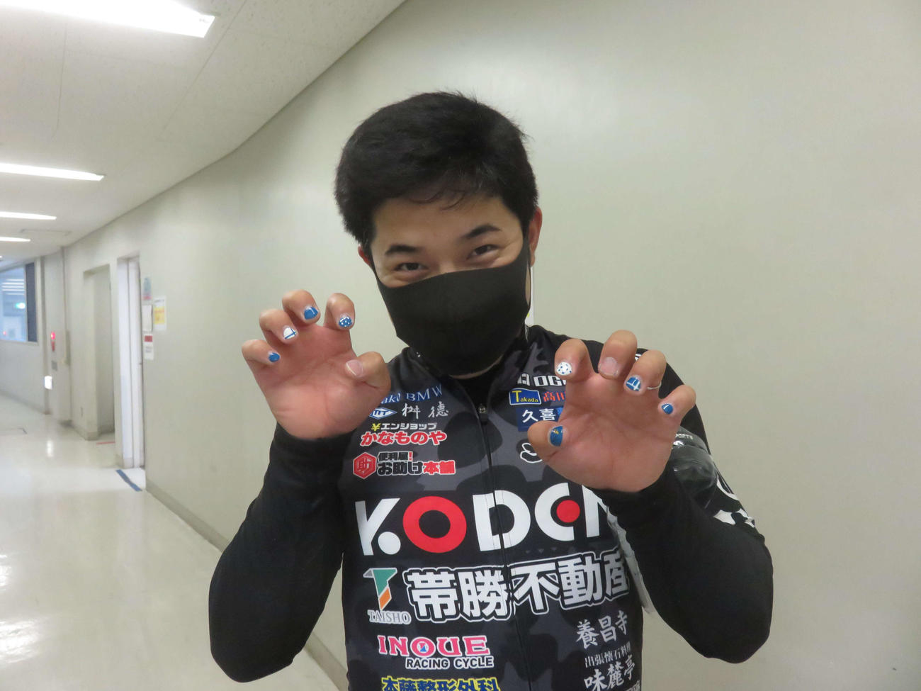 ネイルした指を見せてポーズを決める小玉勇一