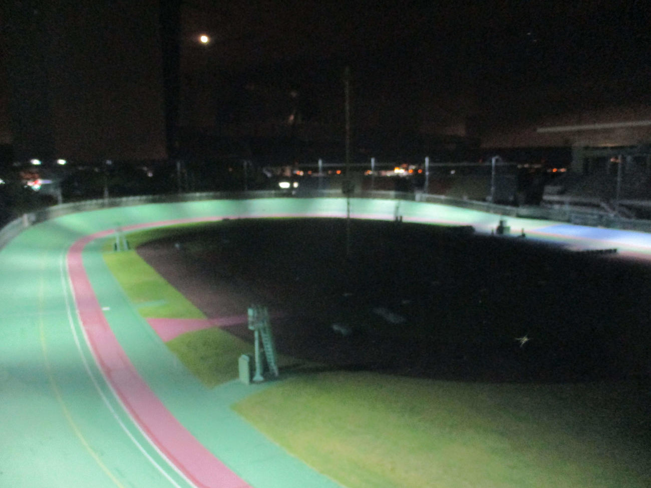 向日町競輪場のバンクは非常灯で照らされている走路意外は闇に包まれた。