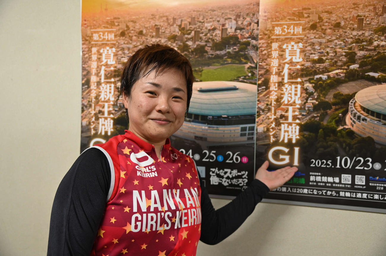 寛仁親王牌のポスターの前でポーズを決める杉沢毛伊子