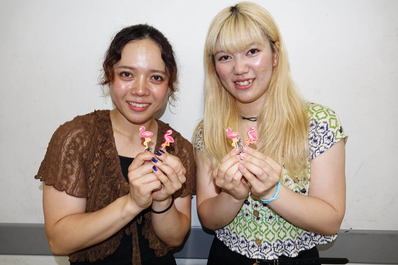 金田舞夏（右）が購入したフラミンゴのフィギュアを手にする熊谷芽緯