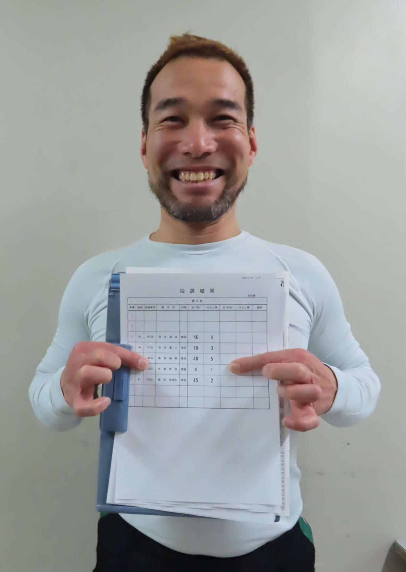 西武園競輪　宇根秀俊が抽選結果を表すプリントを持って笑顔。抽選器から「50」まで記された玉のうち、見事に「4」を引いた（撮影・野島成浩）
