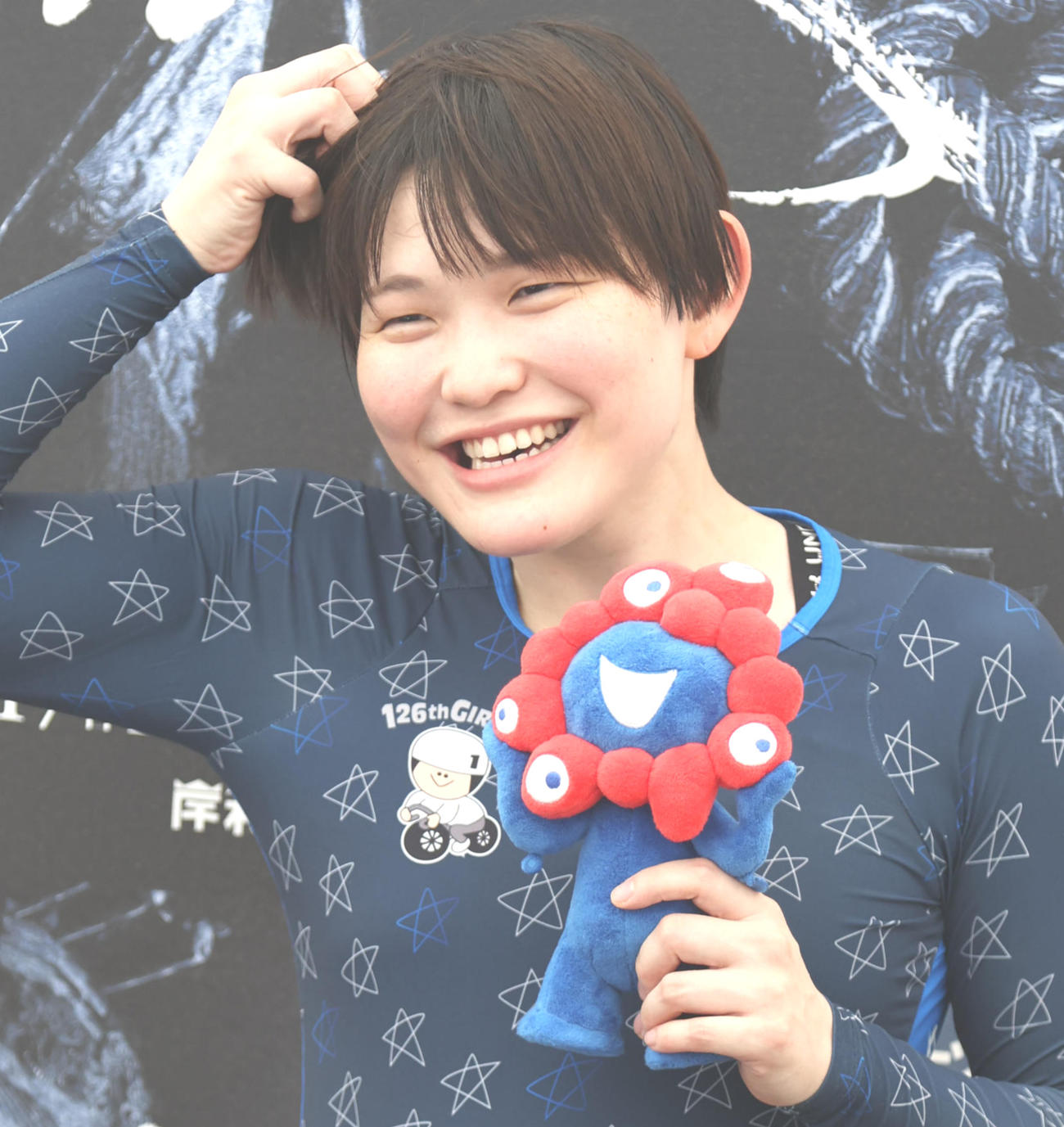 仲沢春香はミャクミャクを手にポーズ