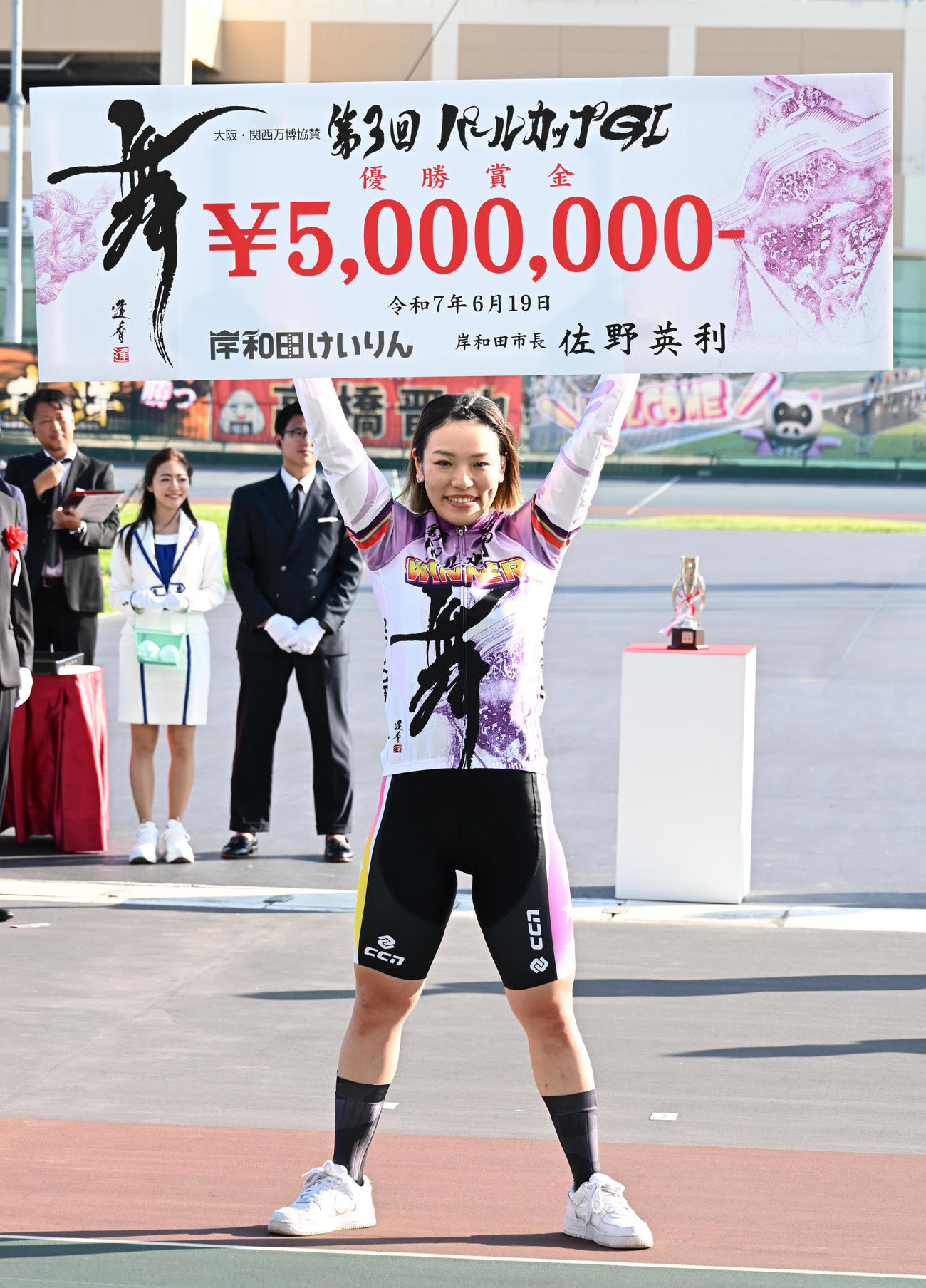 賞金ボードを掲げる佐藤水菜（撮影・石井愛子）