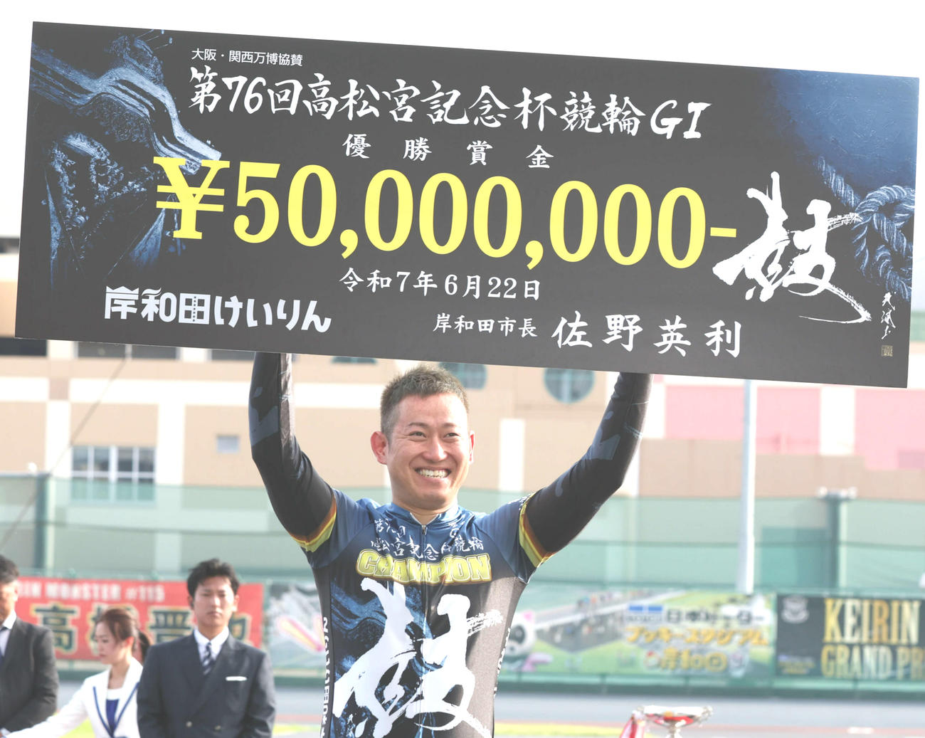 賞金ボードを掲げて笑顔を見せる脇本雄太
