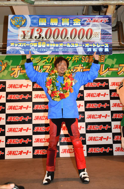 優勝した荒尾聡は賞金ボードを掲げる（撮影・柴田隆二）