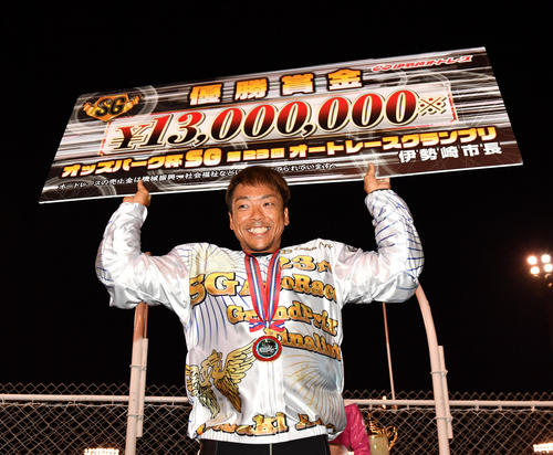 優勝賞金ボードを掲げる青山周平（撮影・柴田隆二）