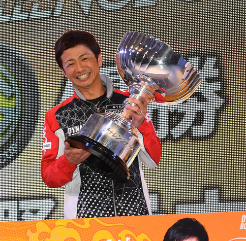 チャレンジカップの優勝杯を掲げる石野貴之（撮影・柴田隆二）