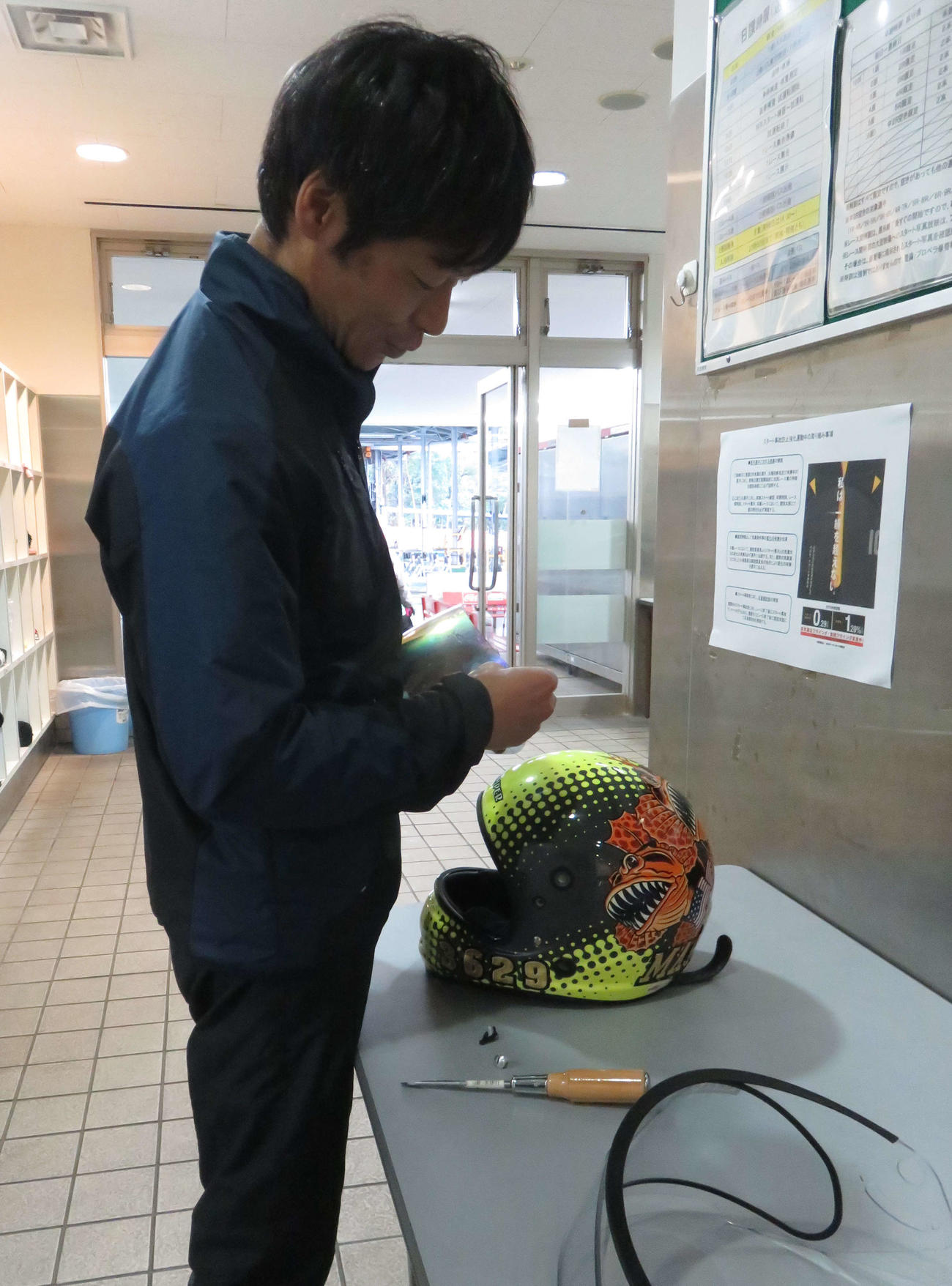 浅見昌克がヘルメットのシールドを交換。手にする方が晴れ用、画像右下が曇り止めが施された雨用