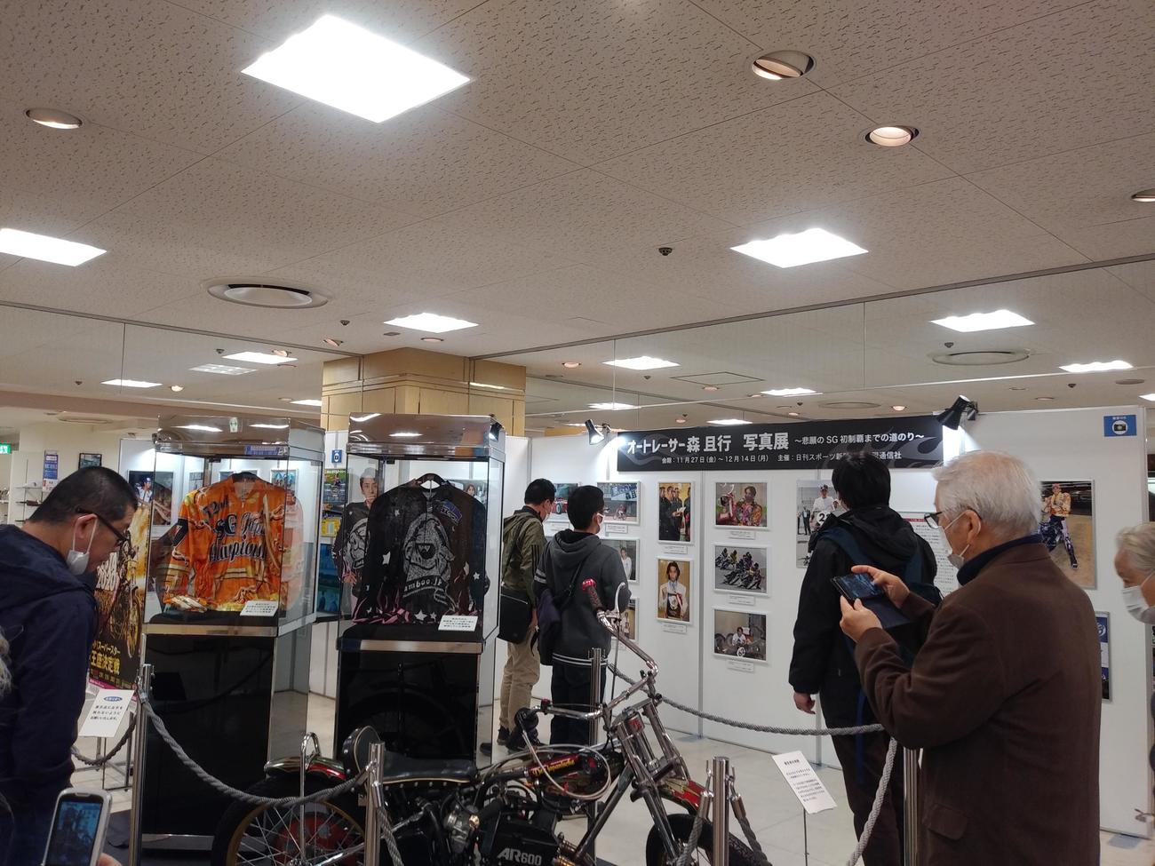 森且行の写真を多くのファンが熱心に見ていた。手前は勝負服と競走車（撮影・田中聖二）