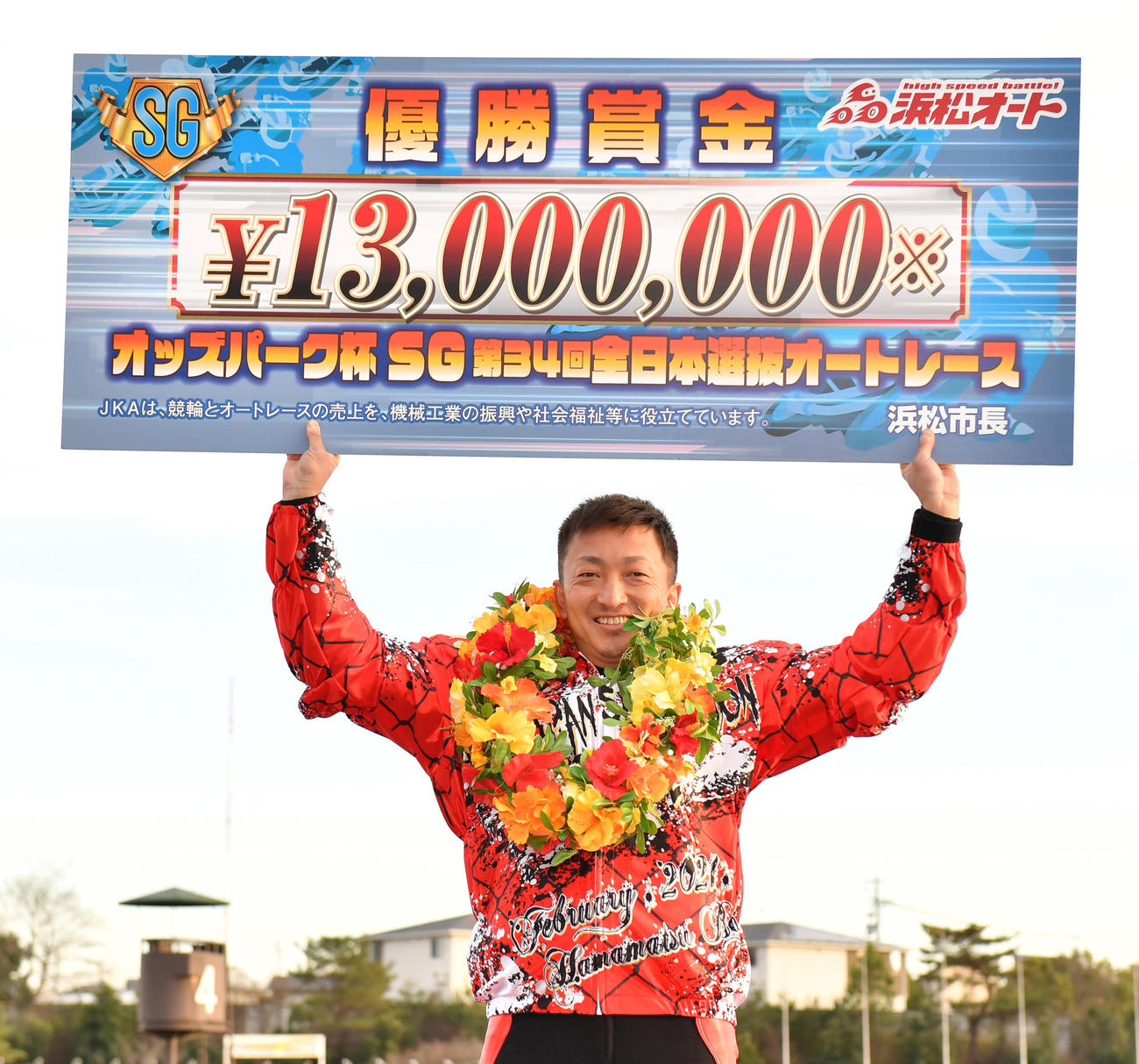 優勝した荒尾聡は賞金ボードを掲げる（撮影・柴田隆二）