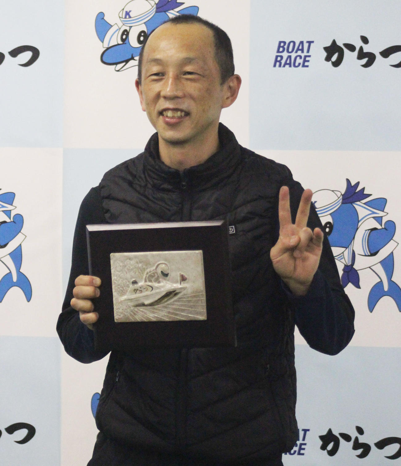 通算2000勝を達成した安田政彦は、記念盾を手に笑顔を見せた