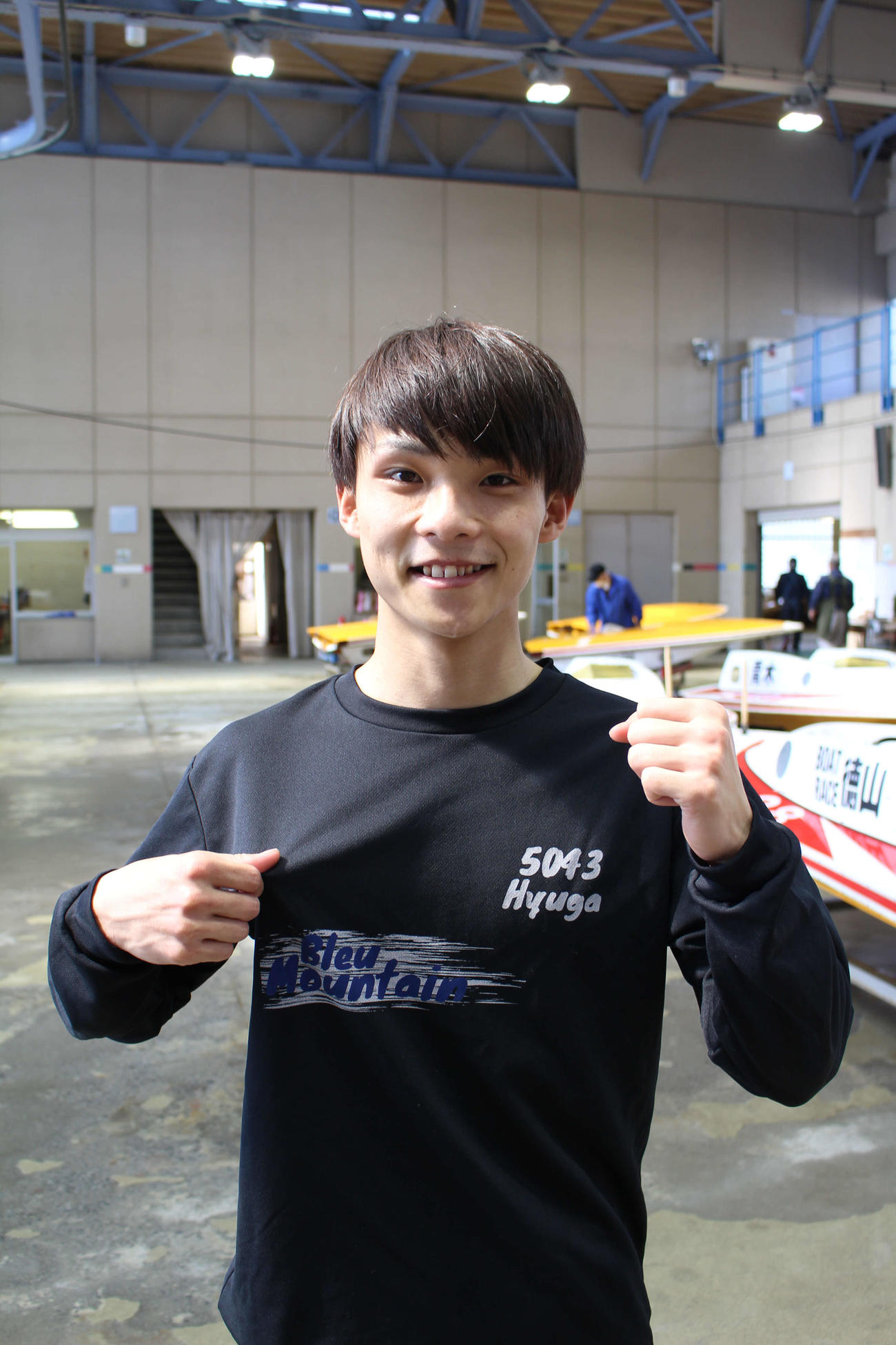中村日向がチーム名の入ったTシャツをアピールする
