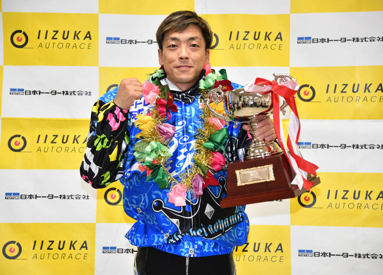 優勝カップを手にガッツポーズする青山周平（撮影・岩下翔太）