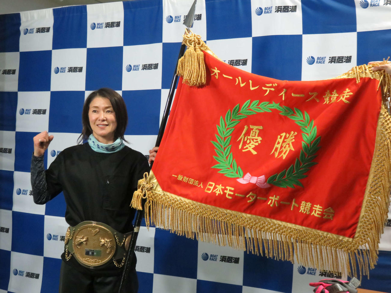 オールレディースの優勝旗と優勝ベルトとともに、優勝を喜ぶ池田浩美（撮影・窪寺伸行）