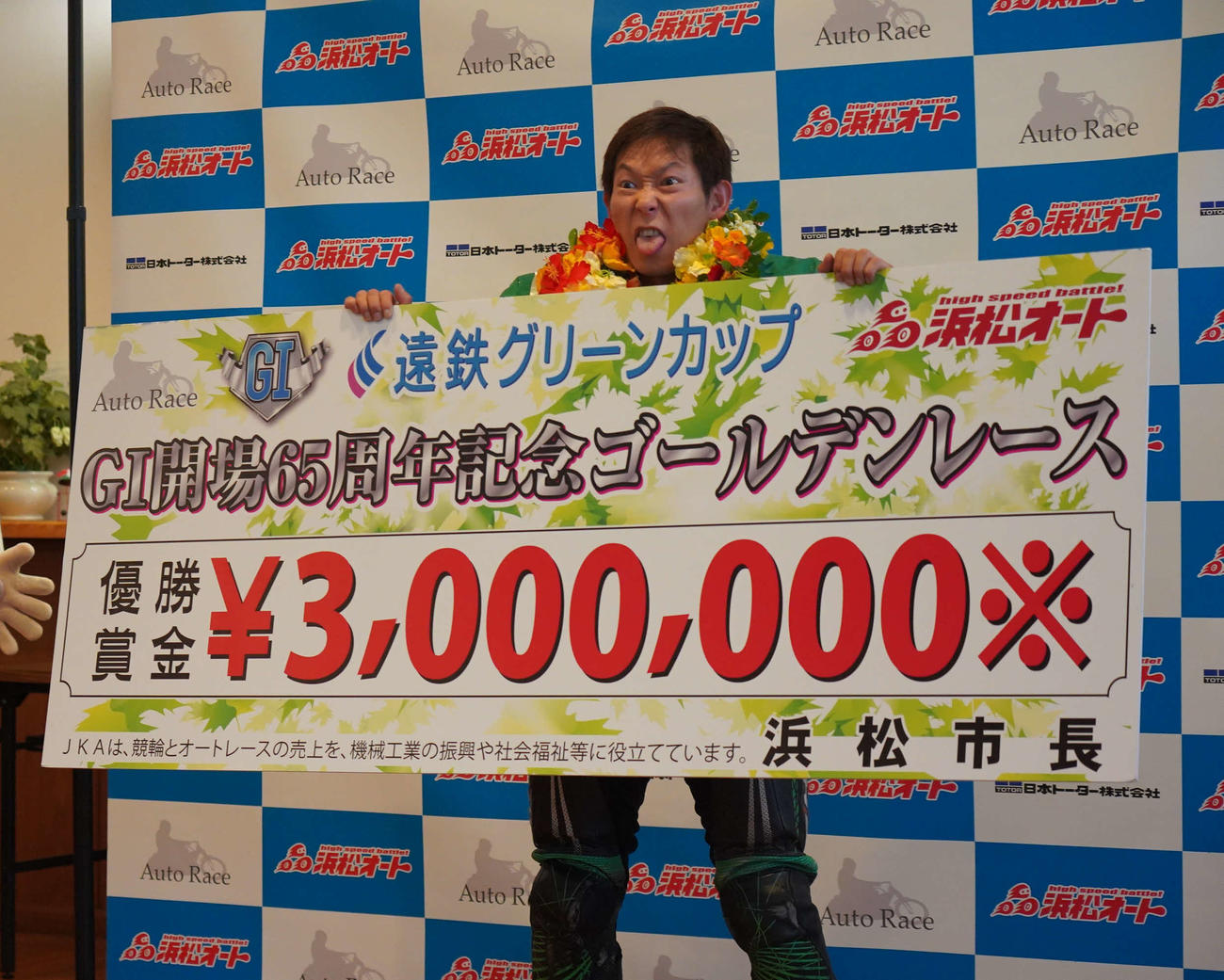 佐藤貴也が賞金ボードを手に、プロレスラーみたいな表情で写真を撮影