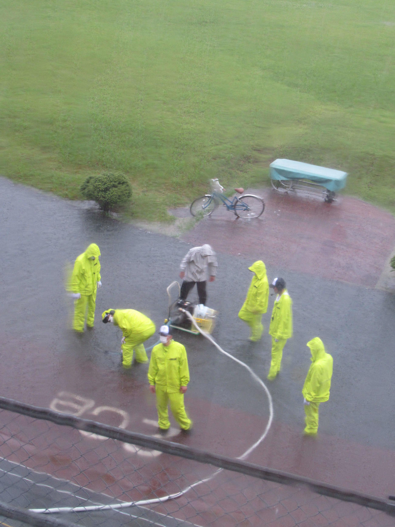 6Rあたりから強くなった雨の影響でレースが中断。2センター付近で、係員がポンプで除水作業を行った（撮影・岡田晋）