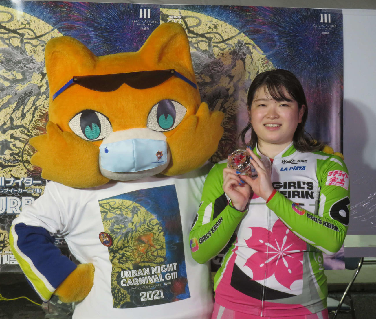 川崎競輪場イメージキャラクター「九ちゃん」と写真に収まる尾方真生（撮影・栗田文人）