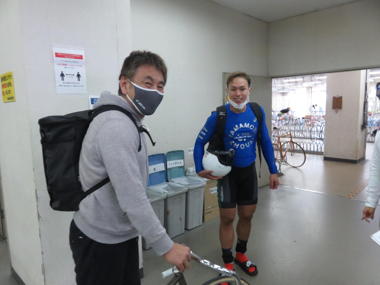 誘導を終えた師匠の山崎充央（左）から激励を受ける山本勝利