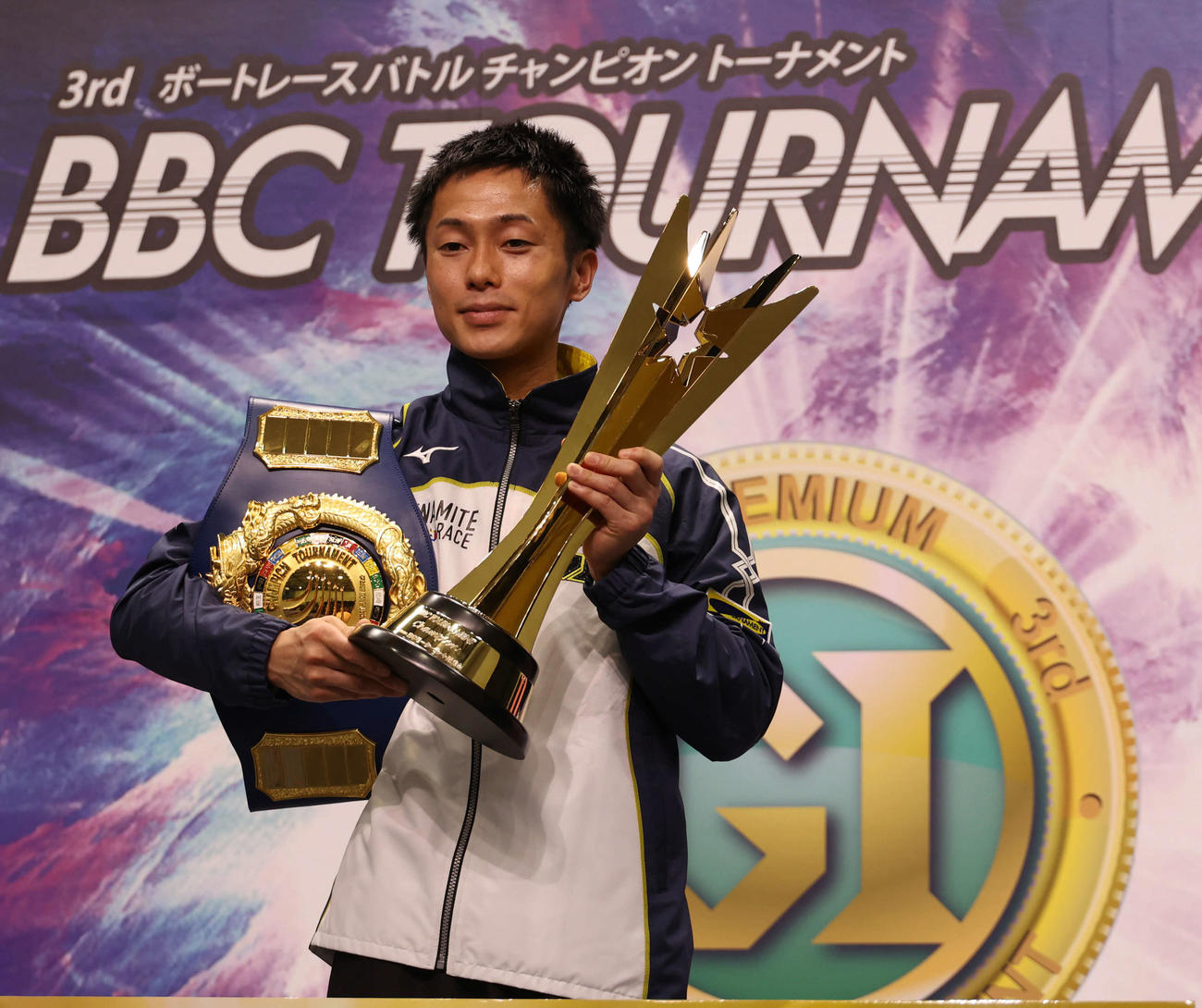 チャンピオンベルトとトロフィーを手にする丸野一樹（撮影・渦原淳）