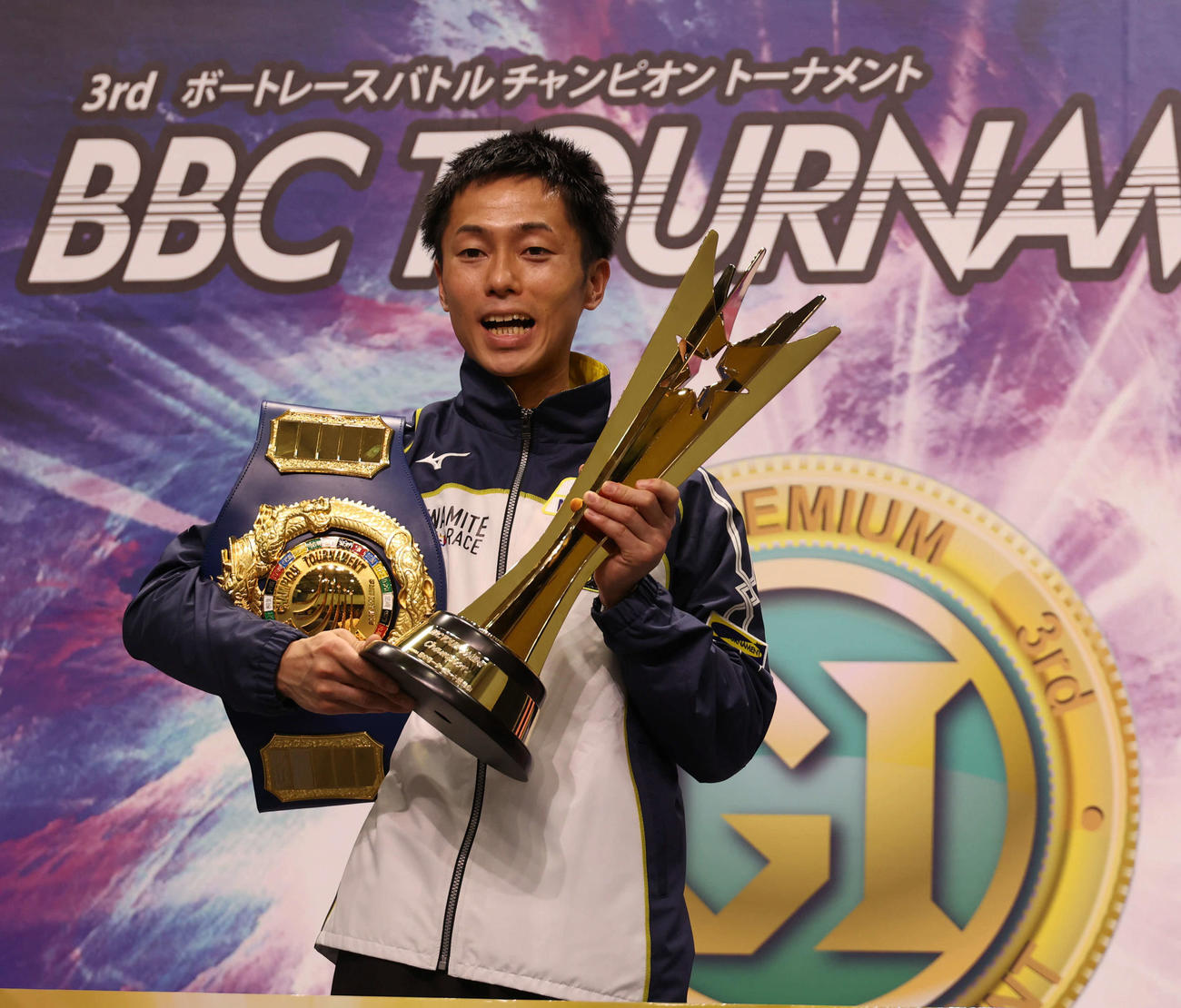 チャンピオンベルトとトロフィーを手にする丸野一樹（撮影・渦原淳）
