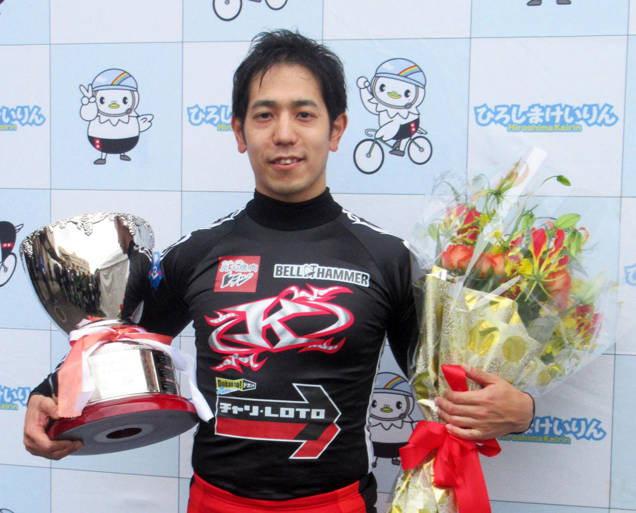優勝カップと花束を手にした松浦悠士