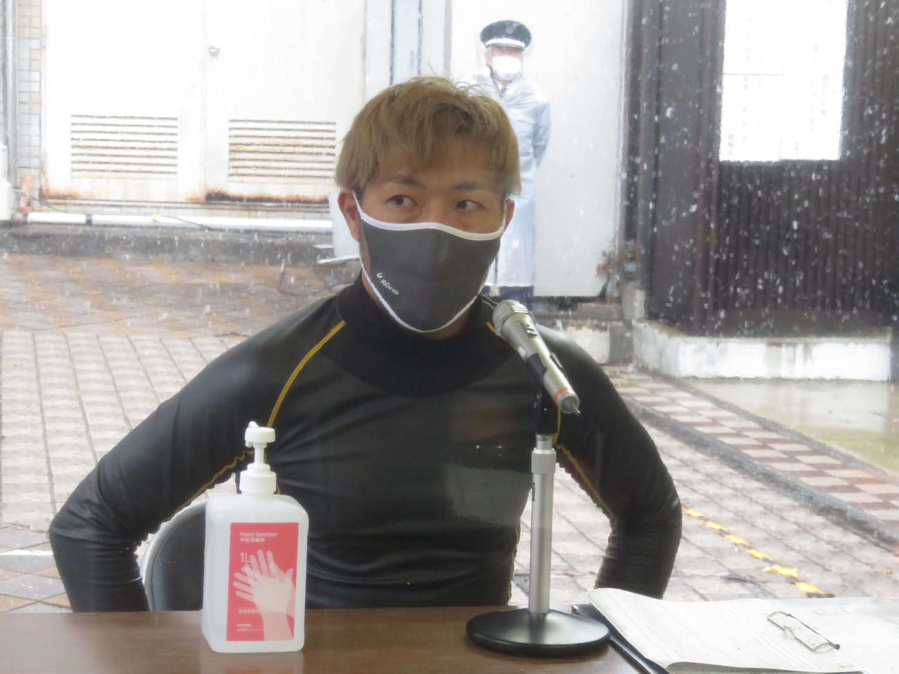 雪が降りしきる中、インタビューに応じる内藤秀久