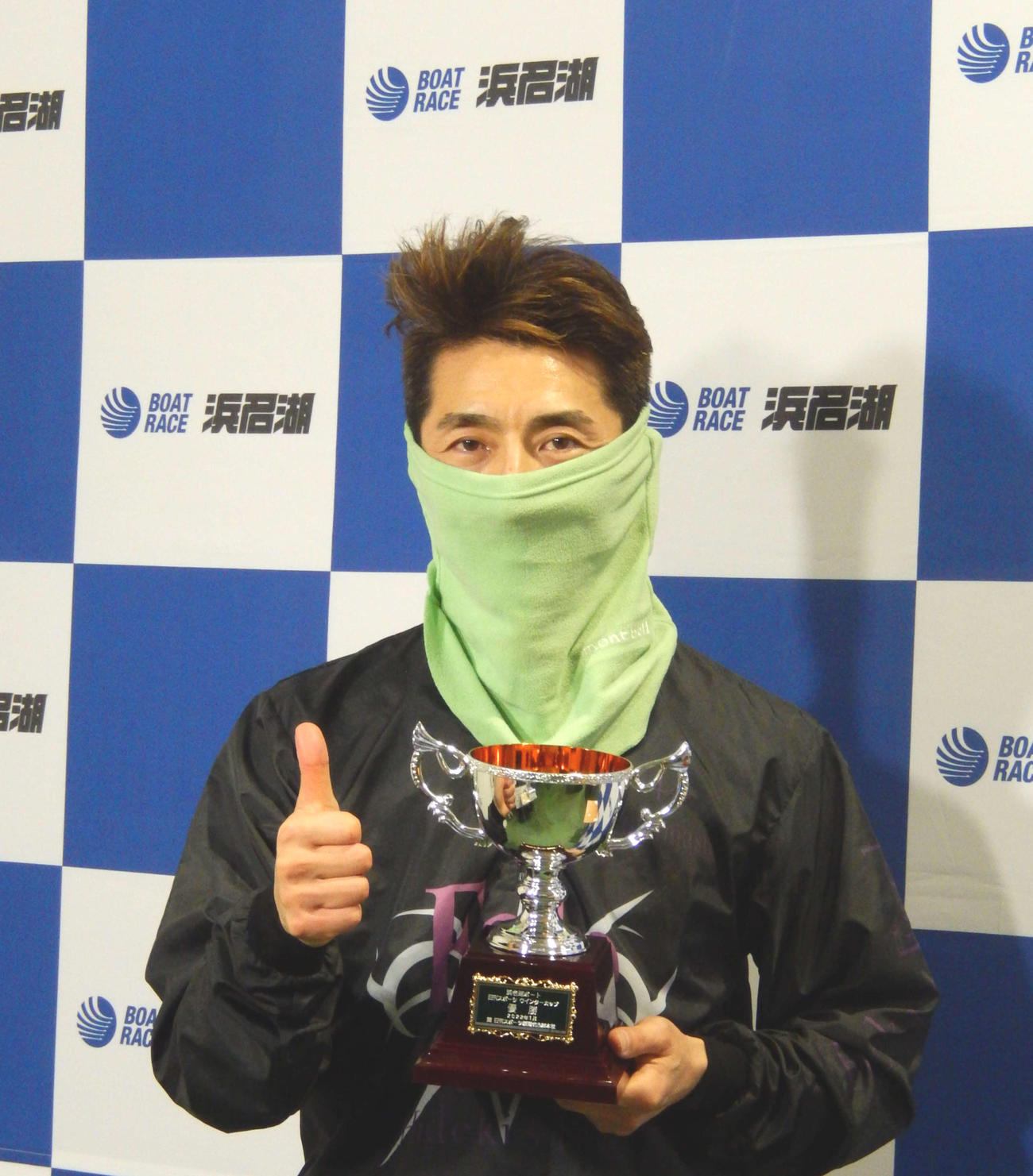 優勝を飾った徳増秀樹が、日刊スポーツ杯を手にサムアップ