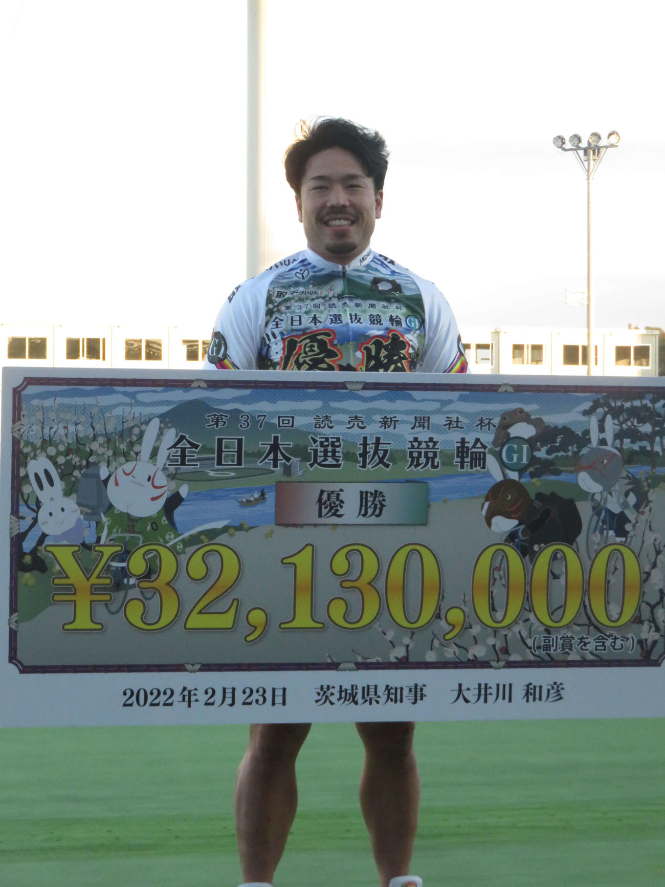賞金ボードを手に笑みをこぼす古性優作
