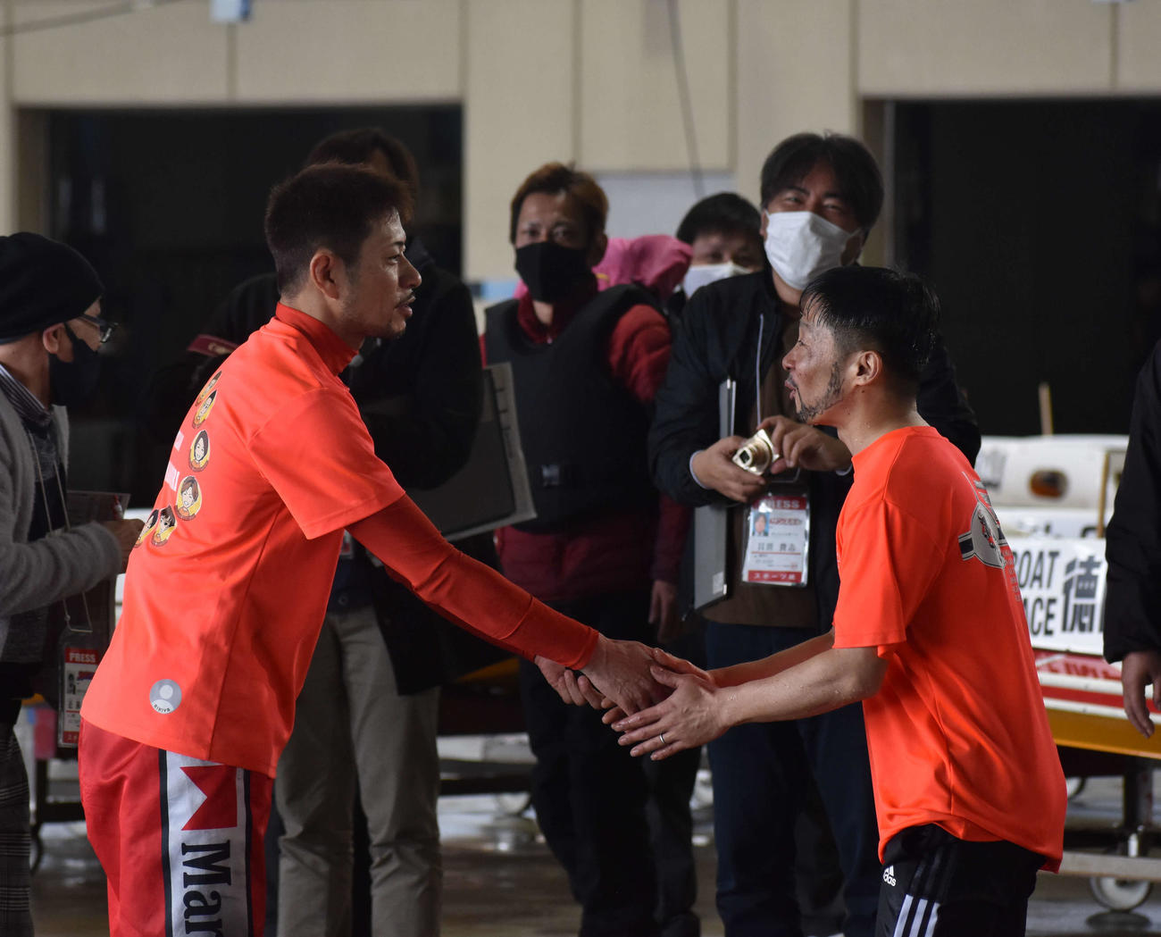 握手を交わす村上純（右）と国弘翔平（左）