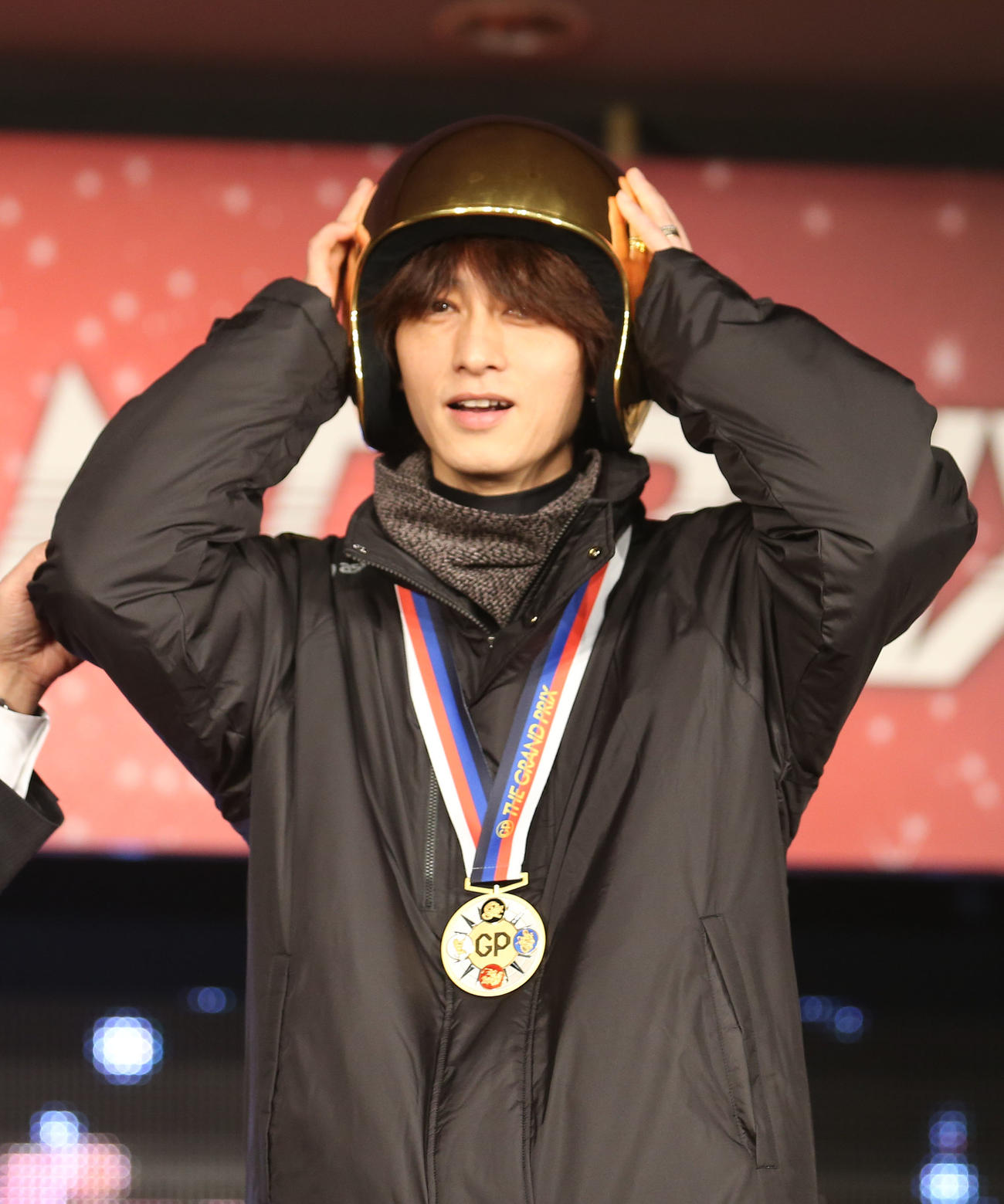 15年12月、グランプの表彰式で黄金のヘルメットの感触を確かめる山崎智也