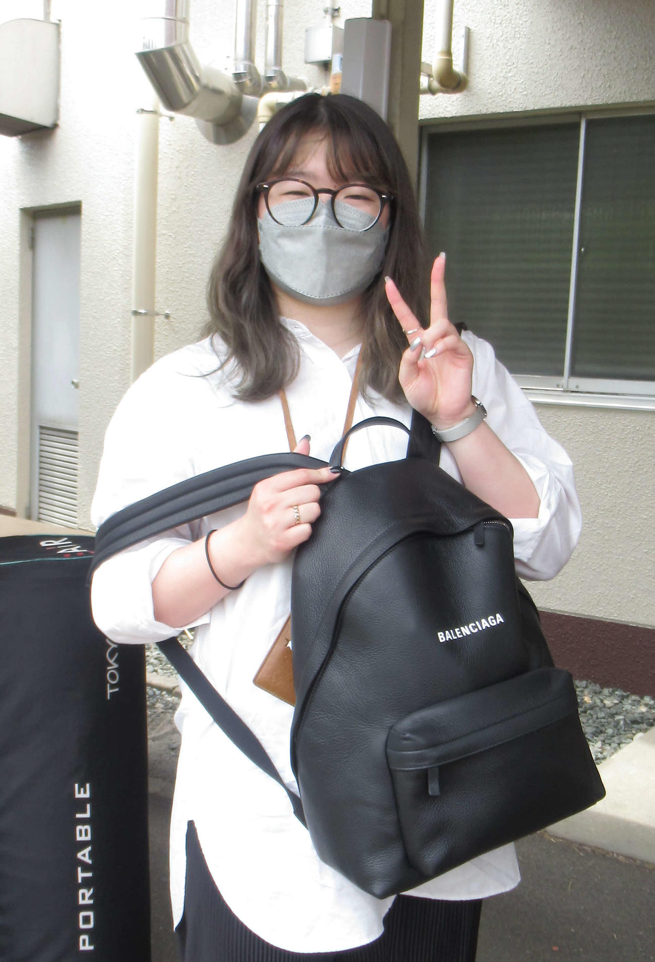尾方真生がお母さんからお祝いにもらったリュックを手にピースサイン（撮影・山田敏明）