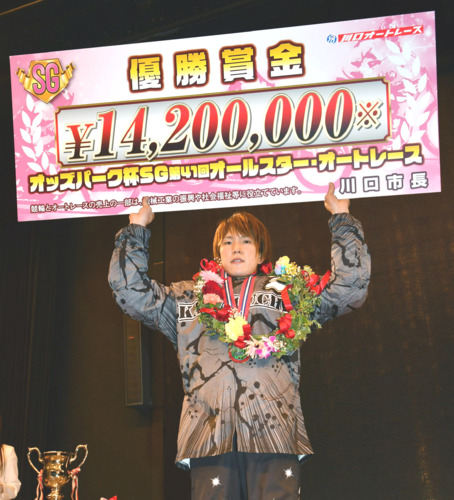 賞金ボードを掲げる鈴木圭一郎(撮影・柴田隆二)