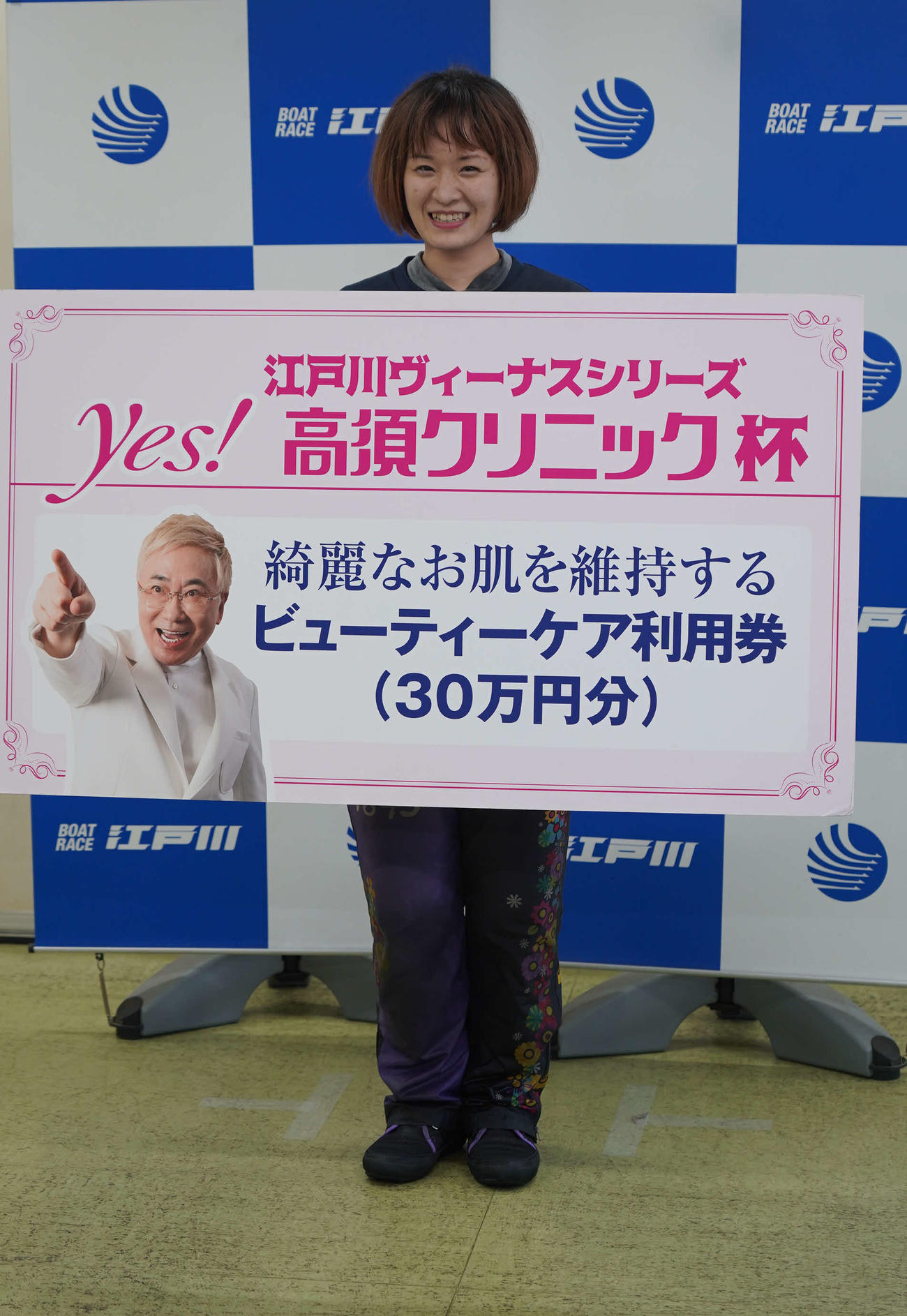 前田紗希がデビュー初優勝。副賞の高須クリニックビューティーケア利用券ボードを手に笑顔