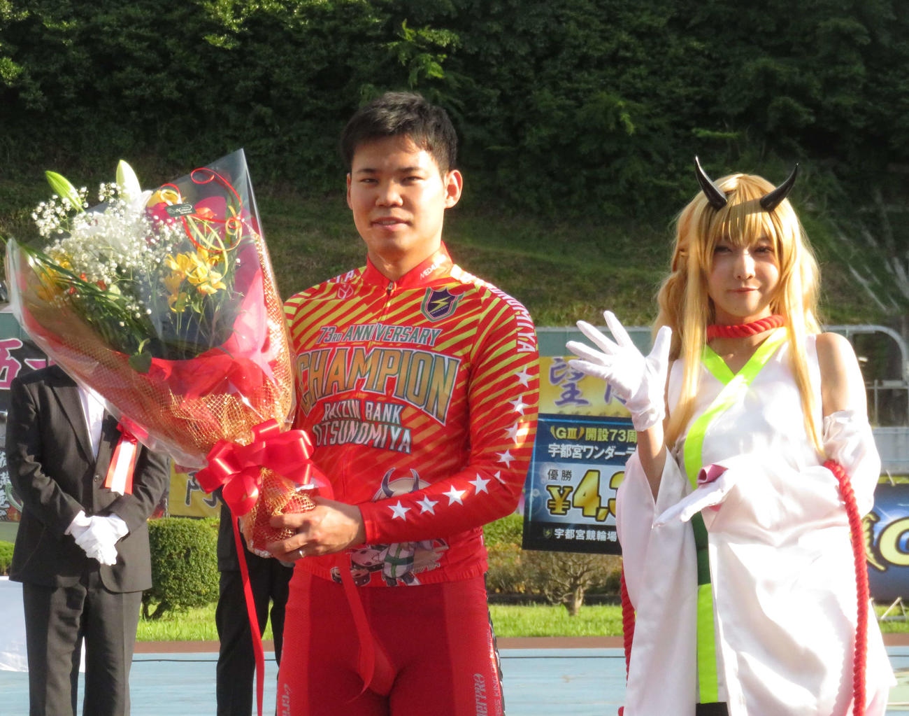 表彰式で吉田拓矢（左）がプロコスプレイヤーの火将ロシエルさんから祝福を受ける