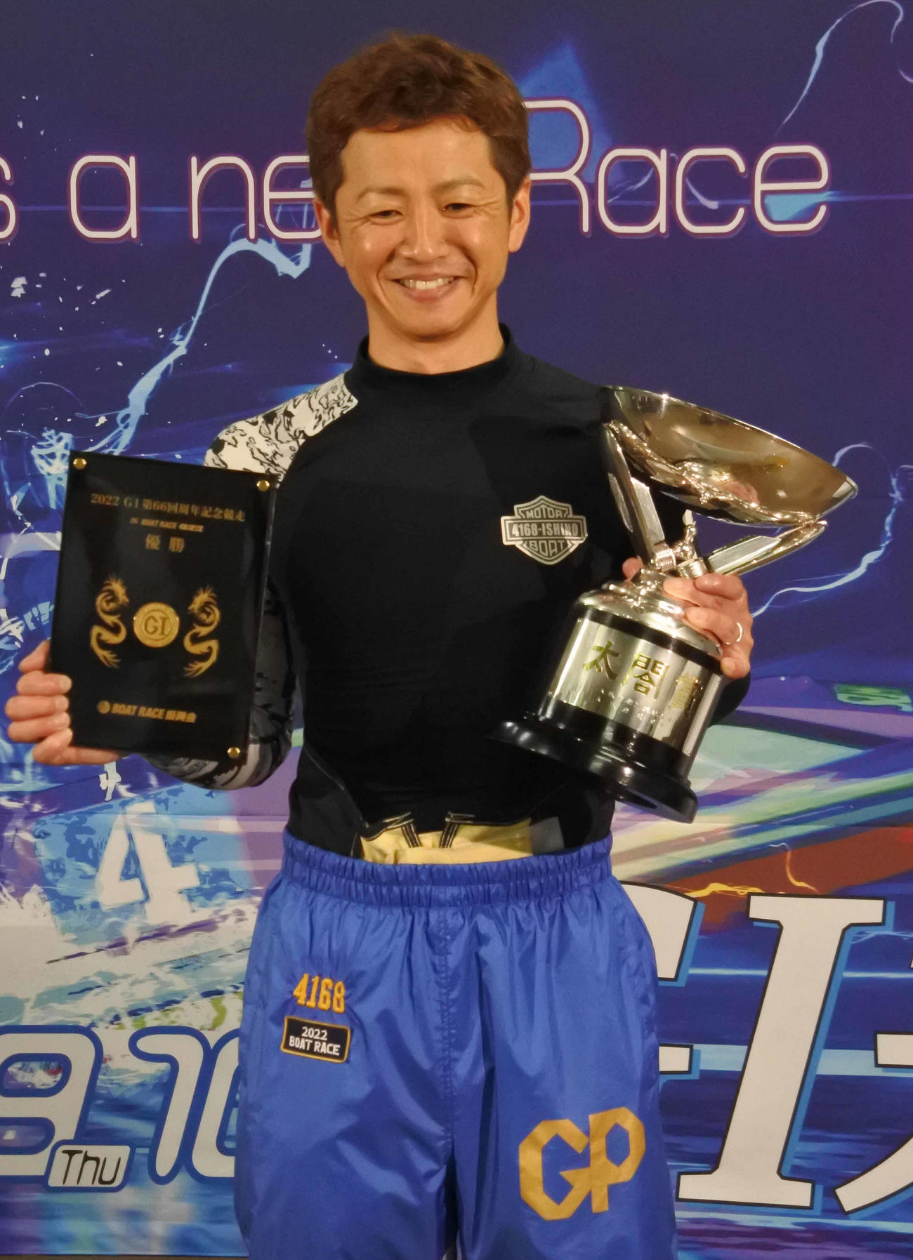 石野貴之は純金メダル盾と優勝カップを手に満面の笑みを浮かべた
