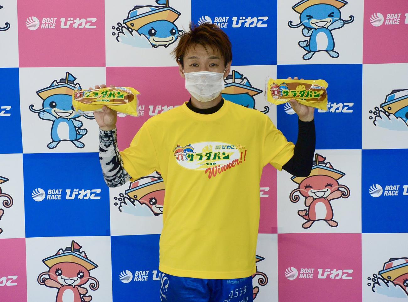 優勝戦を制した金子賢志が、両手に滋賀名物サラダパンを手にガッツポーズ