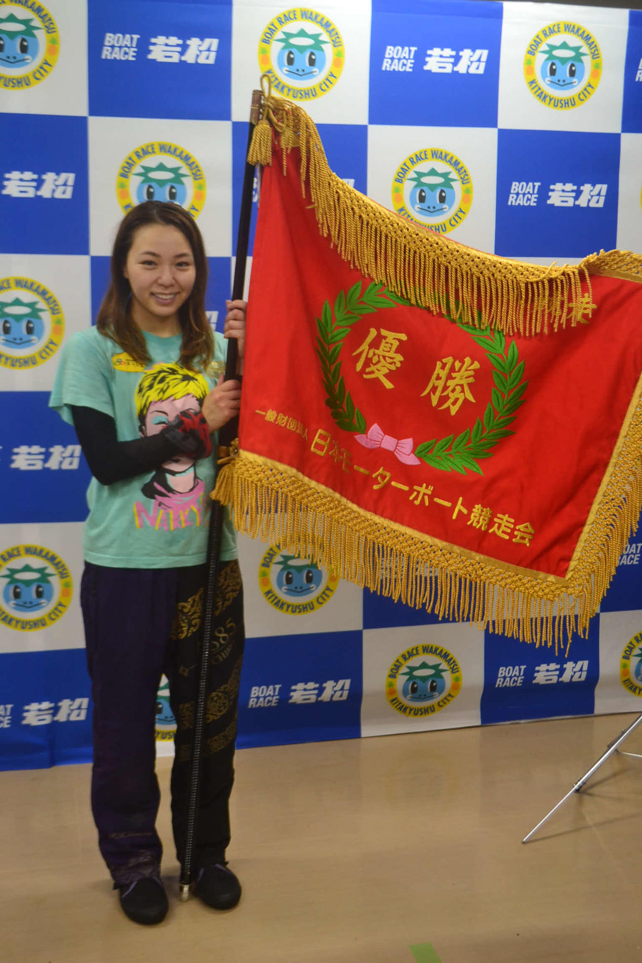 逃げて今年優勝を決めた大山千広は、優勝旗を手に笑顔を見せた