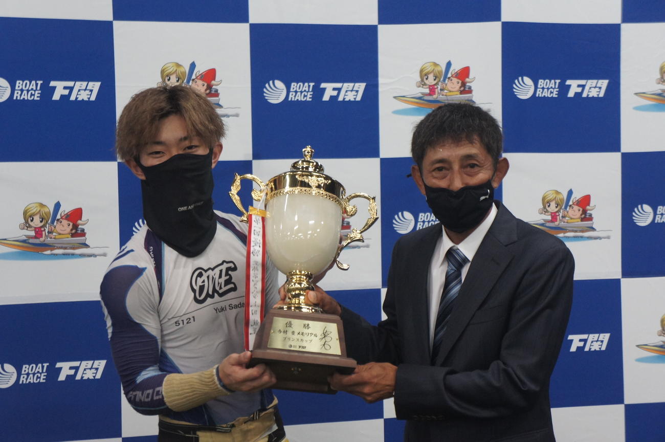 定松勇樹が初優勝を達成しプレゼンターの今村豊氏から優勝カップを贈呈された