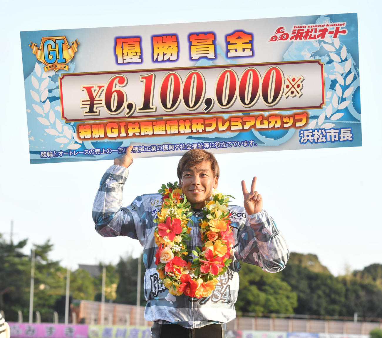 優勝した青山周平は賞金ボードを掲げる（撮影・柴田隆二）