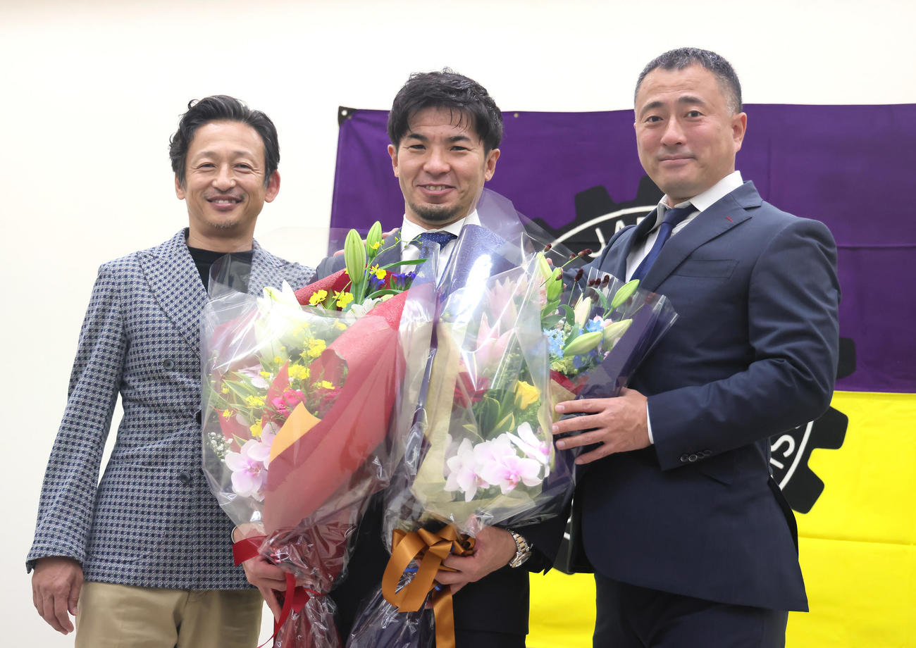 引退会見を行った村上義（中央）に花束を贈り笑顔を見せる山口氏（左）と市田氏（撮影・足立雅史）