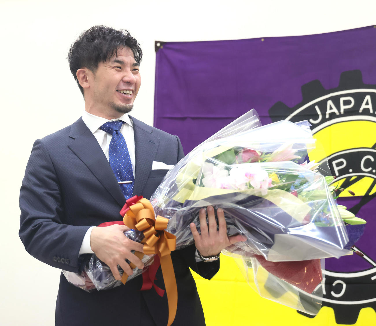 引退会見を終え、花束を手に笑顔を見せる村上義（撮影・足立雅史）