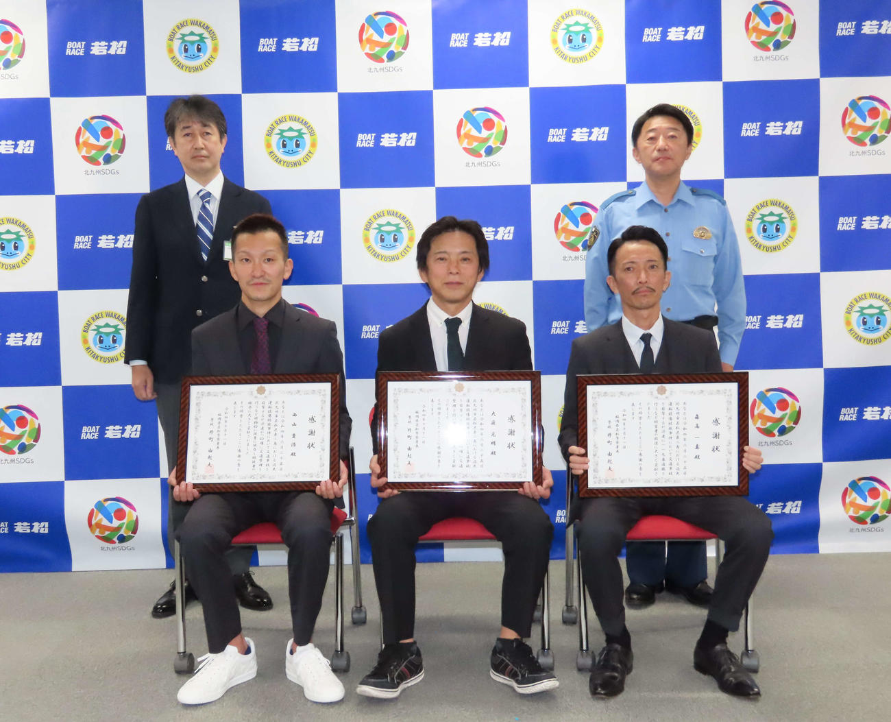 若松警察署から感謝状を受け取った、下段左から西山貴浩選手、大庭元明選手、森高一真選手、上段左から北九州市公営競技局の三浦隆宏局長、若松警察署の井町由起夫署長（撮影・片渕浩介）